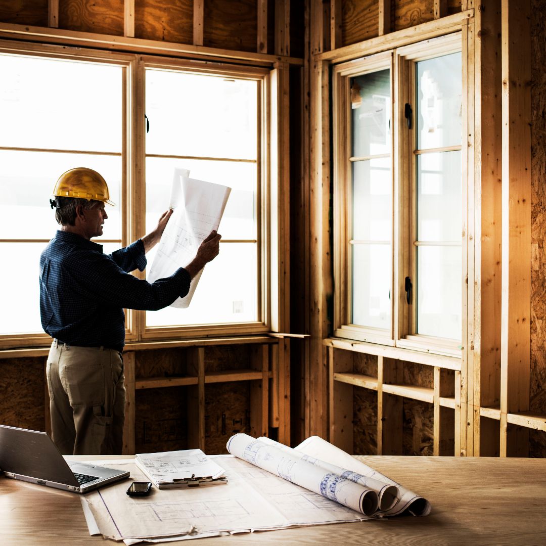 builder holding up papers in construction area