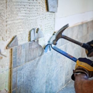 someone hammering tile off a wall